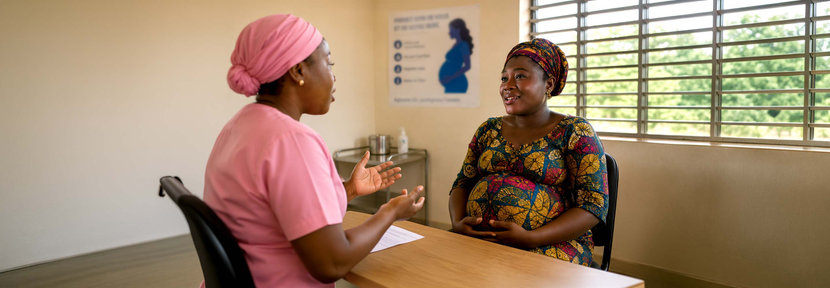 Doctor with pregnant lady in a doctor's surgery