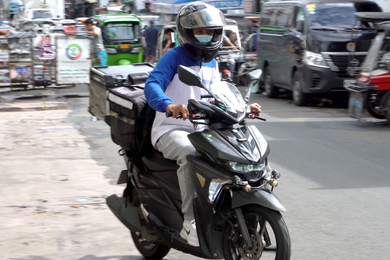 Man on motorcycle carrying samples