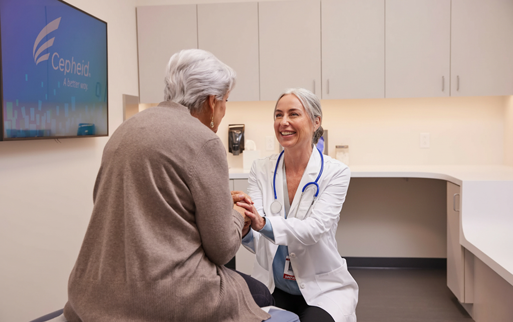 a smiling female doctor attends an elderly woman