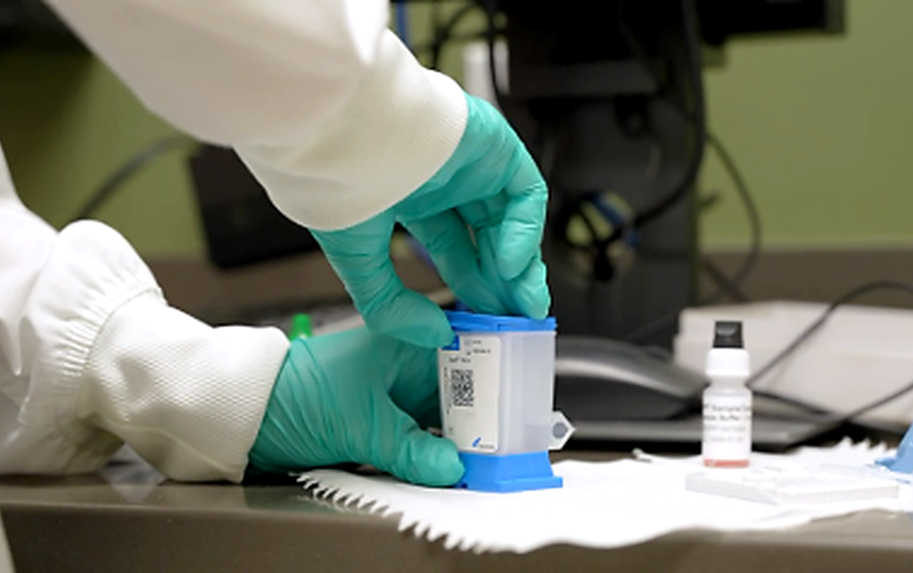 a male and a female researchers scanning cepheid test cartridges